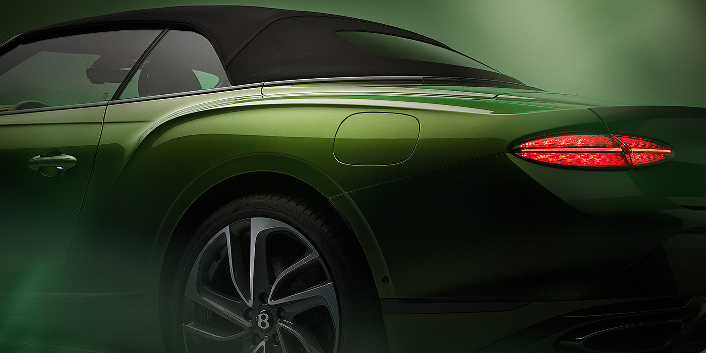 Bentley Bucuresti Bentley New Continental GTC Speed rear haunch and tail lamp in Tourmaline Green paint and dark tint brightware with black hood up and illuminated head lamps