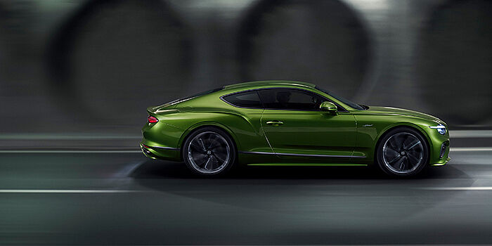  Bentley Bucuresti Bentley Continental GT coupe in Tourmaline Green paint driving in profile on a dark road