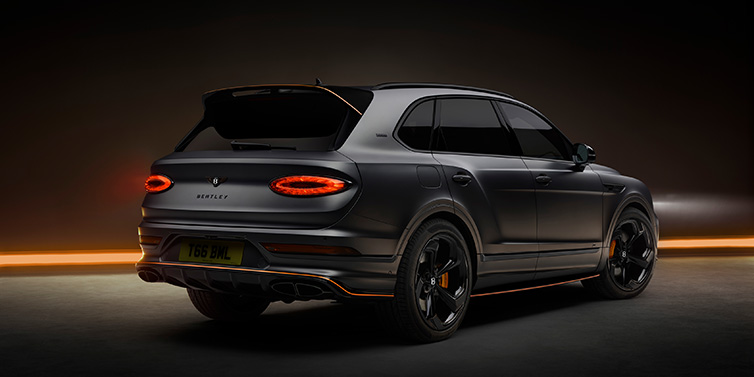 Bentley Bucuresti Bentley Bentayga S Black Edition SUV rear three quarter in Anthracite Satin paint against a dark red and yellow background