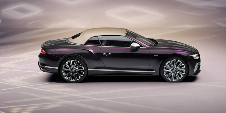 Bentley Bucuresti Bentley Continental GTC Mulliner convertible in profile with hood up, in Tanzanite Purple paint and 22 inch Mulliner painted and polished wheels