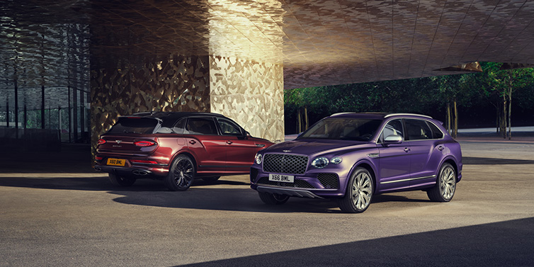 Bentley Bucuresti A duo of Bentley Bentayga Extended Wheelbase Mulliner SUVs parked in a city environment, with Tanzanite Purple and Cricket Ball red exterior paint