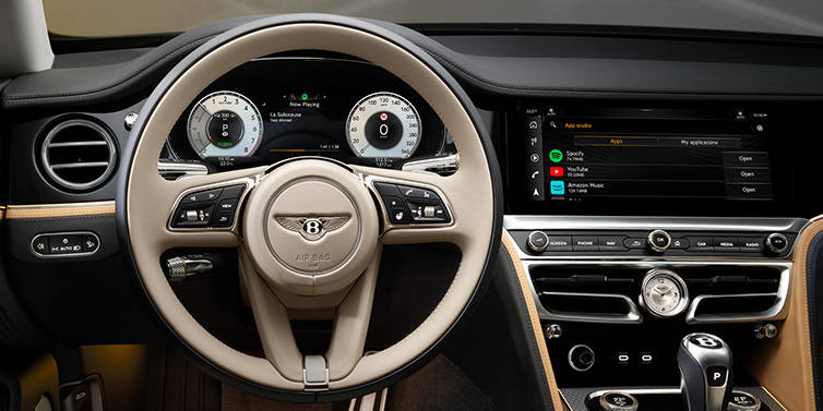 Bentley Bucuresti Bentley Flying Spur Mulliner sedan front interior detail of steering wheel and driver screens surrounded by Linen and Beluga black hides