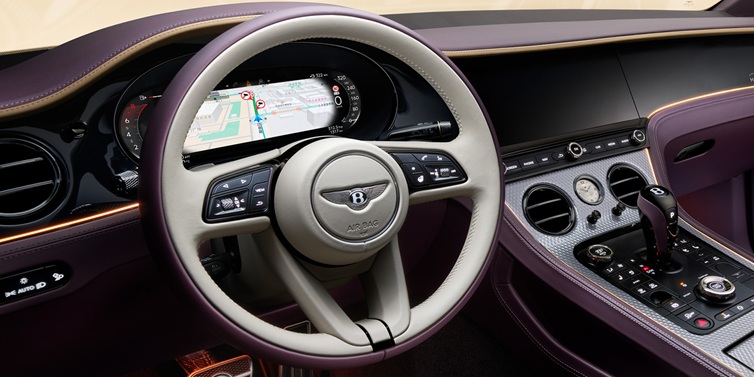 Bentley Bucuresti Bentley Continental GT Mulliner coupe front interior showing steering wheel and drivers screens surrounded by Linen and Damson hides and Grand Black veneer